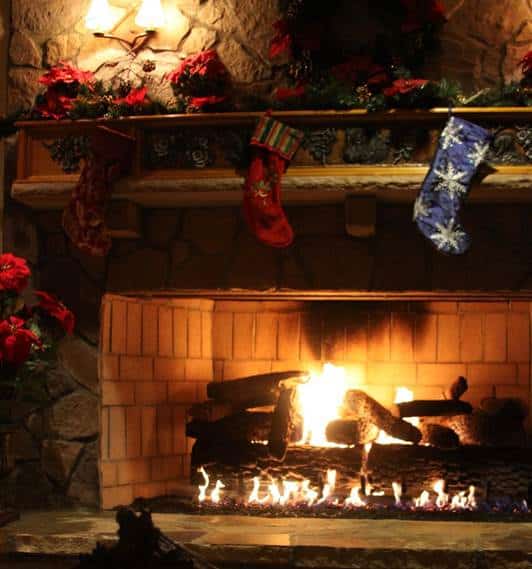 Christmas stockings hung along a mantelpiece above a lit fire